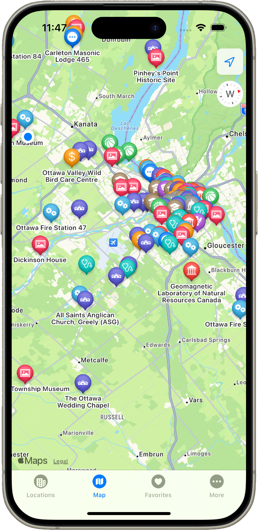 Screenshot of a map application on a mobile phone. The map is centered on the intersection of Pinhey's Point Road and Carleton Lodge Road. Text labels on the map include Pinhey's Point Historic Site, Ottawa Fire Station 47, Gloucester, Blackburn Hamlet, and the Geomagnetic Laboratory of Natural Resources Canada. A menu with icons for Locations, Map, Favourites, and More is visible along the bottom right of the screen.